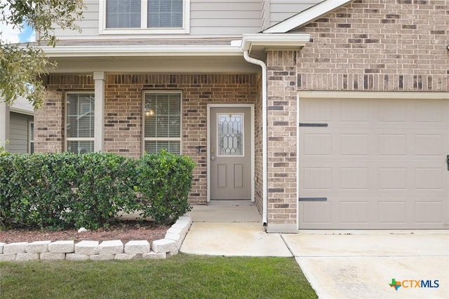 entrance to property featuring a garage and covered porch