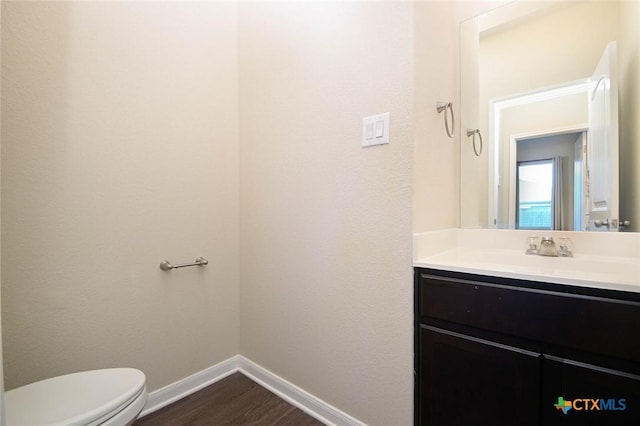 bathroom featuring hardwood / wood-style floors, toilet, and vanity