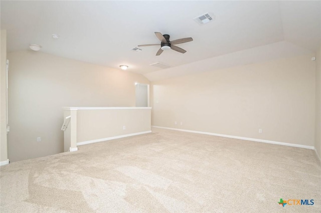 unfurnished room featuring ceiling fan, light colored carpet, and vaulted ceiling