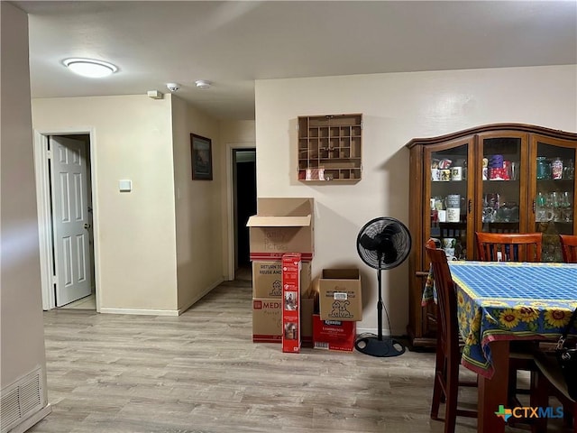 dining space with light wood finished floors, baseboards, and visible vents