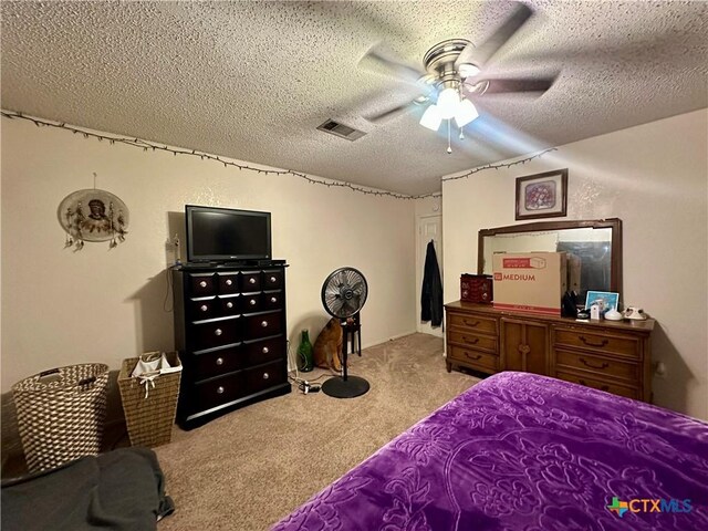 carpeted bedroom with a textured ceiling, visible vents, and ceiling fan