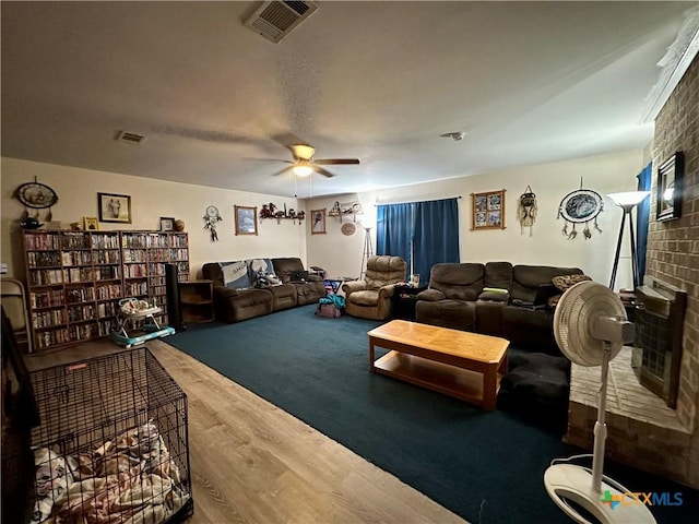 living room featuring visible vents, a ceiling fan, and wood finished floors