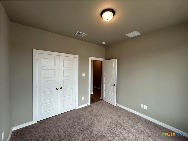 unfurnished bedroom featuring a closet and dark colored carpet