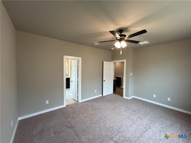 unfurnished bedroom featuring ceiling fan, light colored carpet, and ensuite bath