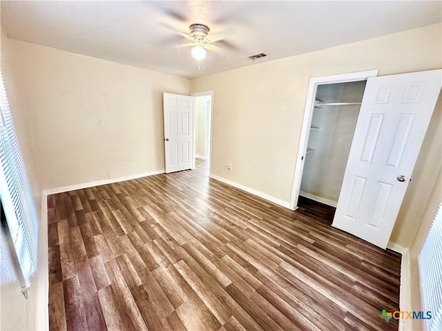 unfurnished bedroom featuring ceiling fan, dark wood-type flooring, and a closet