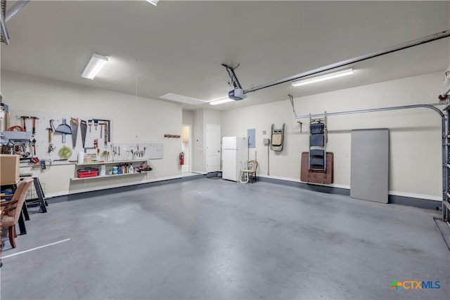 garage featuring a workshop area, electric panel, a garage door opener, and white refrigerator