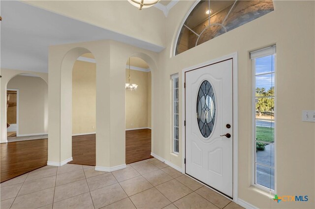 unfurnished living room with a stone fireplace, a raised ceiling, wood-type flooring, and crown molding