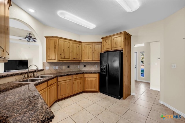 kitchen featuring sink, decorative backsplash, ceiling fan, light tile patterned floors, and black fridge with ice dispenser