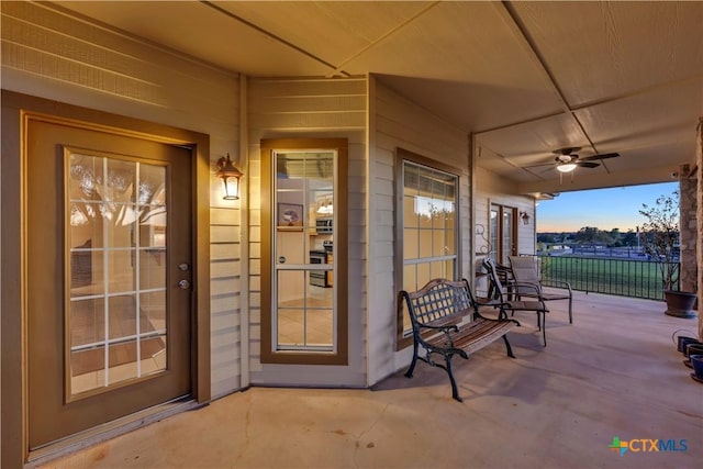 exterior entry at dusk featuring ceiling fan and a porch