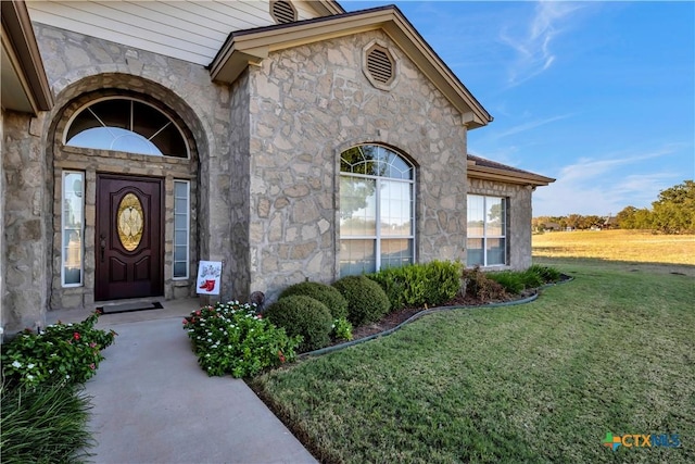 property entrance with a lawn