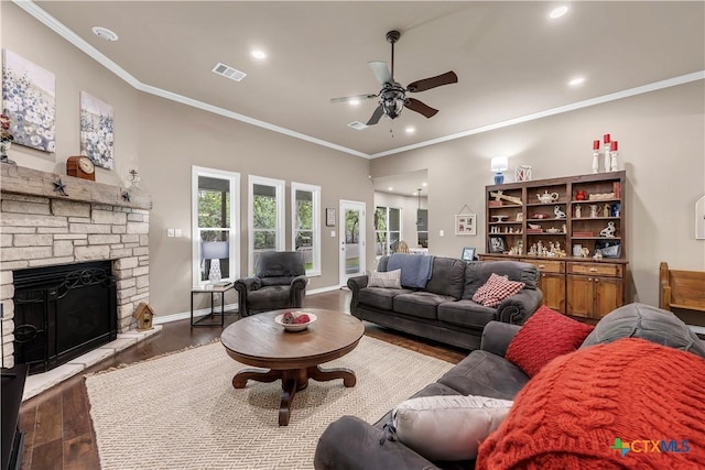 living room featuring a fireplace, ornamental molding, ceiling fan, and dark wood-type flooring