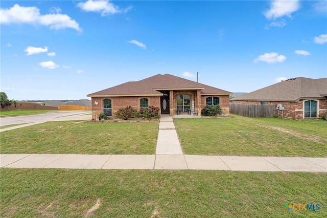 2006 Jesse Dr, Copperas Cove, TX 76522 - view of front of house with fence, a shingled roof, brick siding, a front yard, and concrete driveway