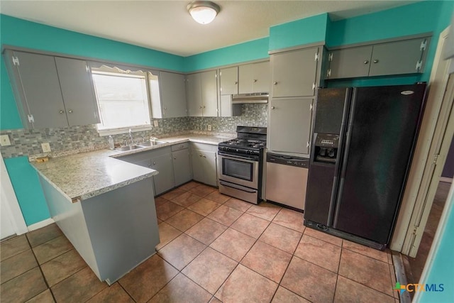 103 Royal Dr, Victoria, TX 77901 - kitchen featuring appliances with stainless steel finishes, a sink, under cabinet range hood, a peninsula, and decorative backsplash