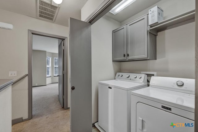 washroom with light colored carpet, cabinets, and washing machine and dryer