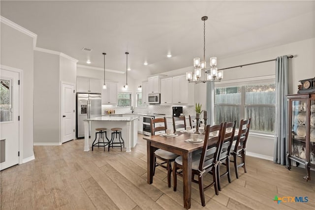 dining space with light wood-style floors, recessed lighting, crown molding, and baseboards