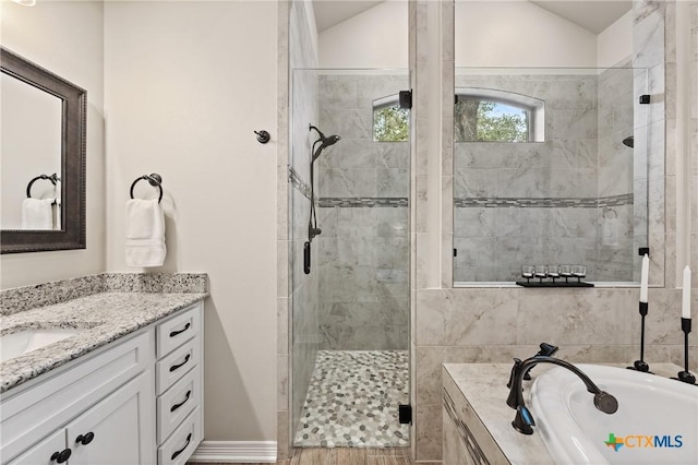 full bathroom featuring a stall shower, vaulted ceiling, vanity, and a bath