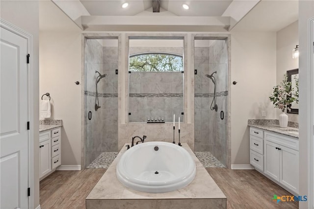 full bath with wood finished floors, vanity, a shower stall, and a bath