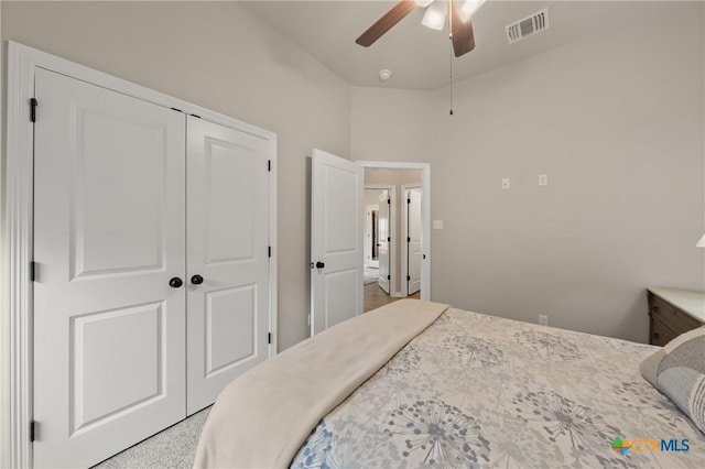 bedroom with ceiling fan, visible vents, and a closet