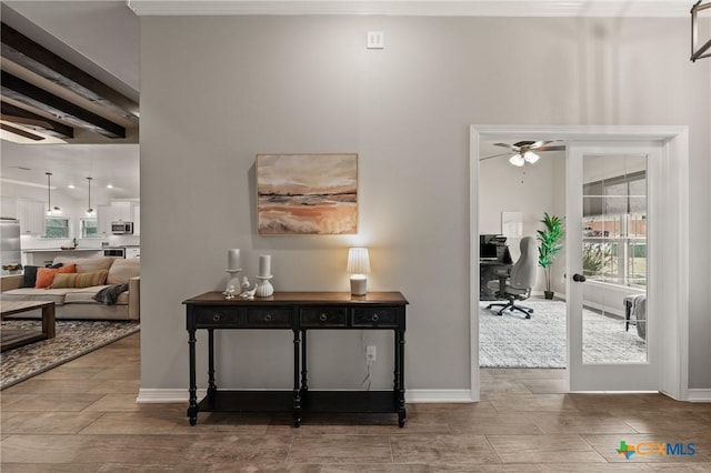 corridor featuring wood tiled floor, beam ceiling, and baseboards