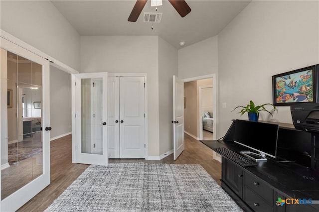 living area with french doors, wood finished floors, visible vents, and baseboards