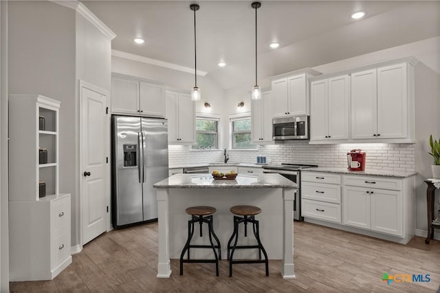 kitchen featuring appliances with stainless steel finishes, light wood-type flooring, white cabinetry, and a sink