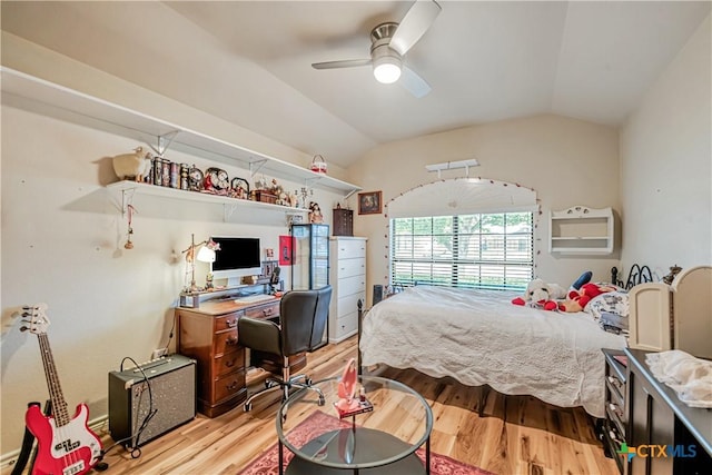 bedroom featuring light wood finished floors, an office area, vaulted ceiling, and a ceiling fan