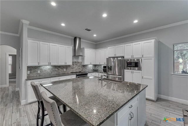 3935 Outpost Trce, Lago Vista, TX 78645 - kitchen featuring appliances with stainless steel finishes, wall chimney range hood, baseboards, white cabinetry, and recessed lighting