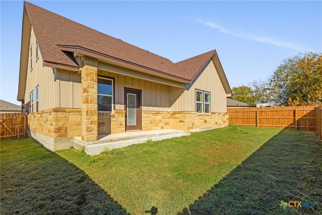 rear view of house featuring a lawn