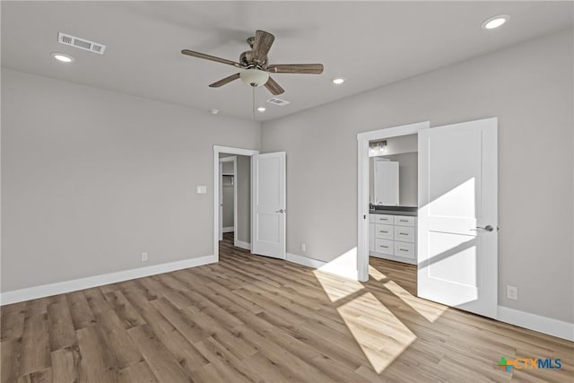 unfurnished bedroom with connected bathroom, light hardwood / wood-style flooring, and ceiling fan