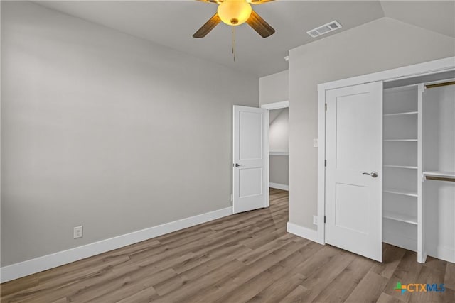 unfurnished bedroom featuring ceiling fan, a closet, light hardwood / wood-style floors, and lofted ceiling