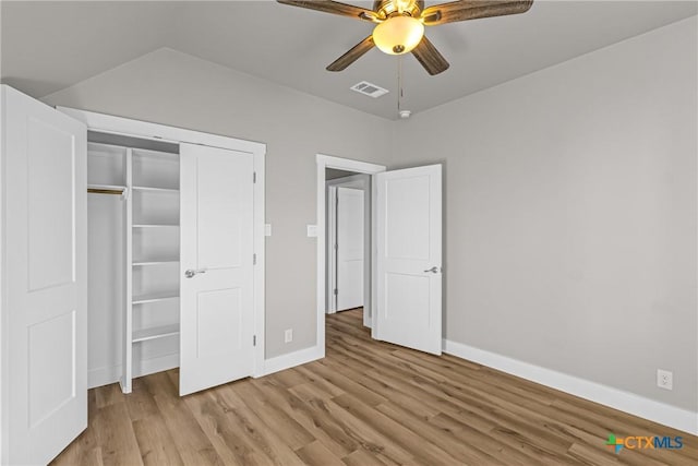 unfurnished bedroom with ceiling fan, a closet, and light wood-type flooring