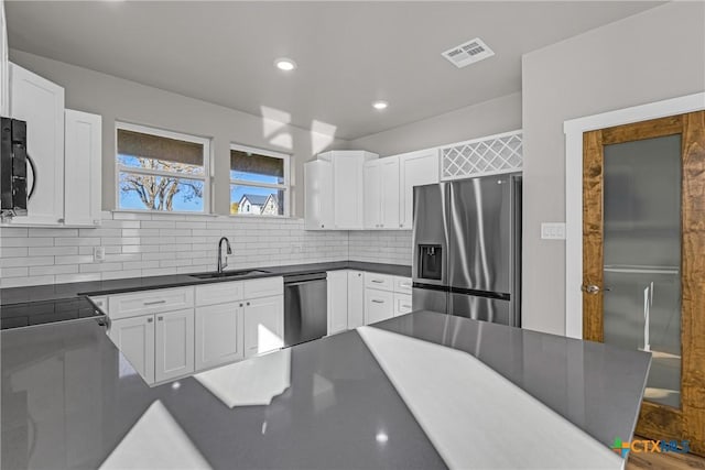 kitchen with backsplash, sink, white cabinets, and appliances with stainless steel finishes