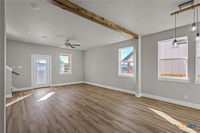 unfurnished living room with hardwood / wood-style flooring, ceiling fan, and beamed ceiling