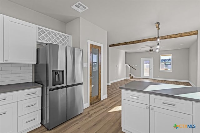 kitchen with stainless steel fridge with ice dispenser, white cabinets, light hardwood / wood-style floors, and decorative light fixtures