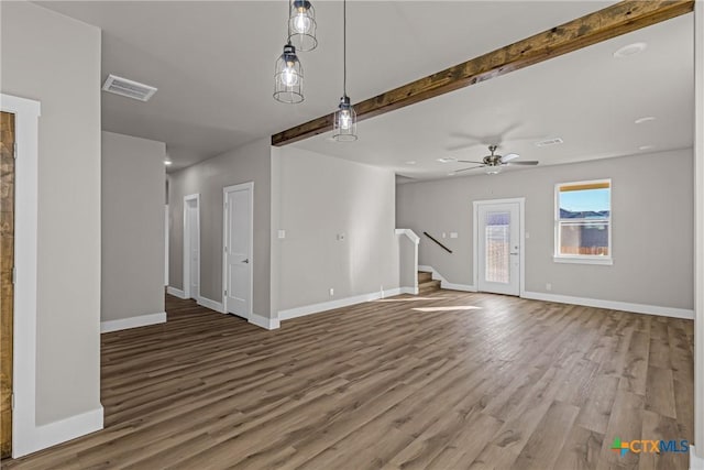 unfurnished living room with beamed ceiling, hardwood / wood-style flooring, and ceiling fan