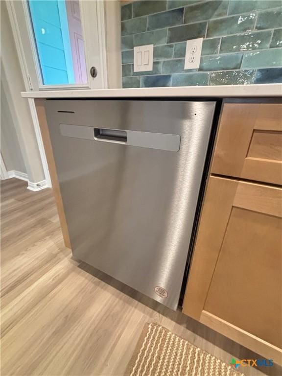 room details with baseboards, stainless steel dishwasher, and light wood-style floors