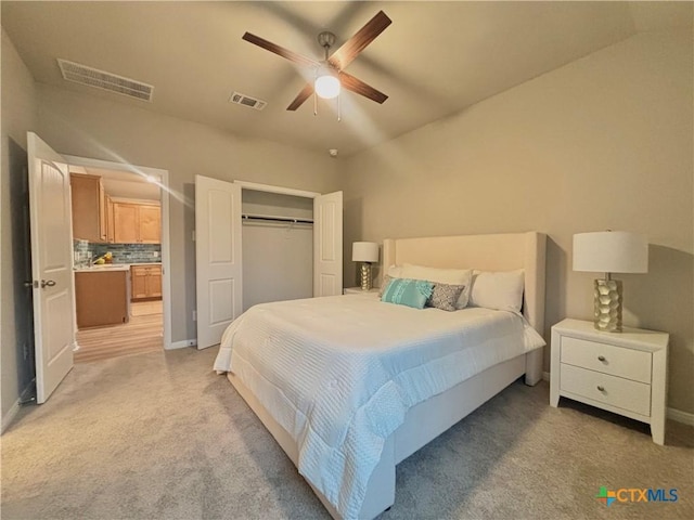 bedroom featuring light carpet, a ceiling fan, visible vents, and a closet