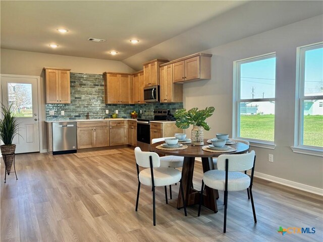 kitchen featuring stainless steel appliances, tasteful backsplash, light countertops, and visible vents