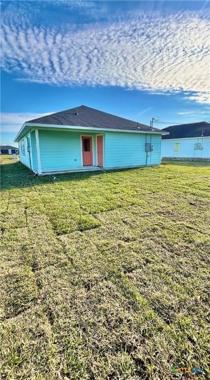 rear view of property featuring a lawn