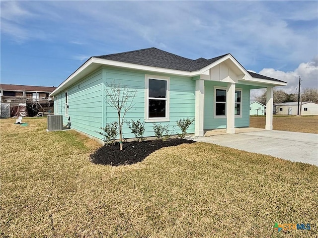 view of front of home featuring central AC, a front lawn, and roof with shingles