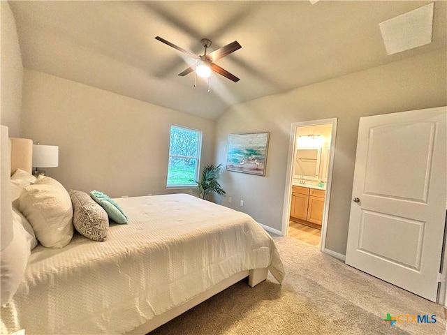 bedroom with lofted ceiling, light carpet, connected bathroom, ceiling fan, and baseboards