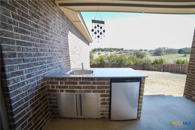 view of patio / terrace with area for grilling, a sink, and fence