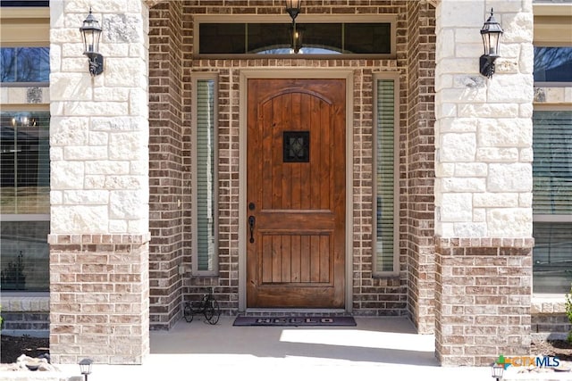 property entrance featuring brick siding and stone siding