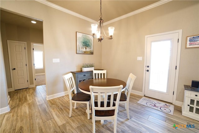 dining room featuring an inviting chandelier, crown molding, light wood-type flooring, and baseboards