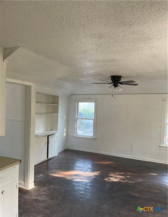 interior space featuring ceiling fan and a textured ceiling