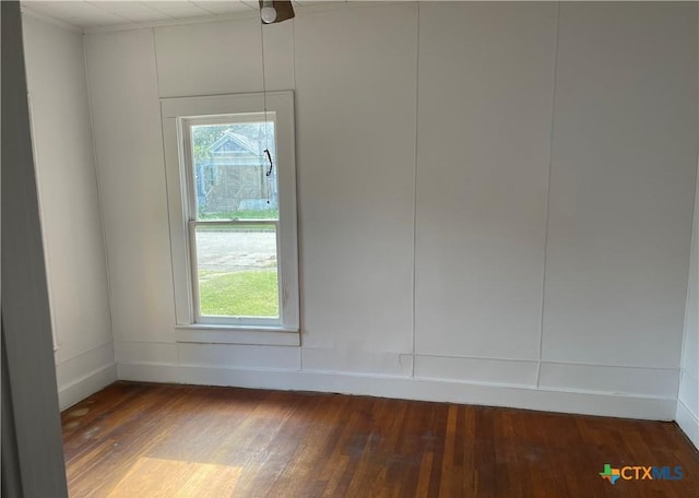 spare room with dark hardwood / wood-style flooring and a wealth of natural light