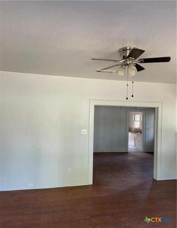 empty room with dark hardwood / wood-style flooring and ceiling fan