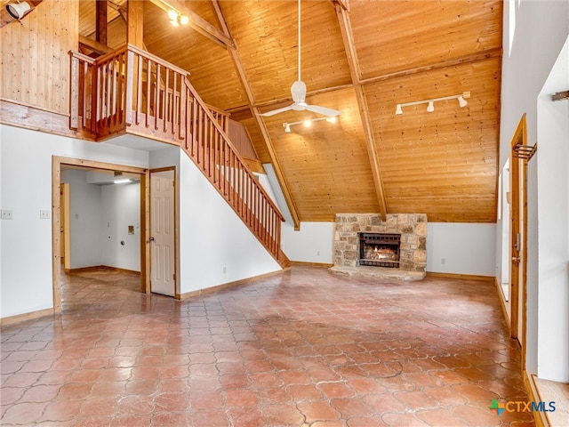 unfurnished living room with high vaulted ceiling, beamed ceiling, wooden ceiling, and ceiling fan