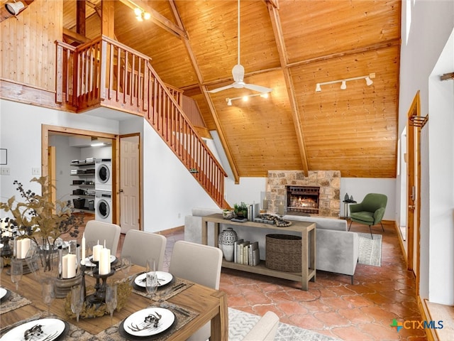 living room with stacked washing maching and dryer, high vaulted ceiling, wood ceiling, beamed ceiling, and ceiling fan