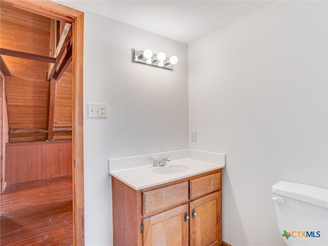 bathroom featuring wood-type flooring, vanity, and toilet